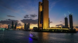 a boat in a body of water near a tall building