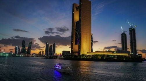 a boat in a body of water near a tall building