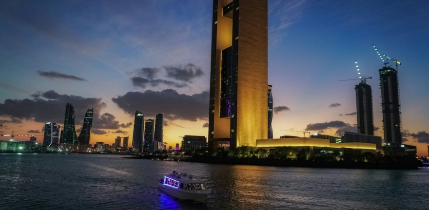a boat in a body of water near a tall building